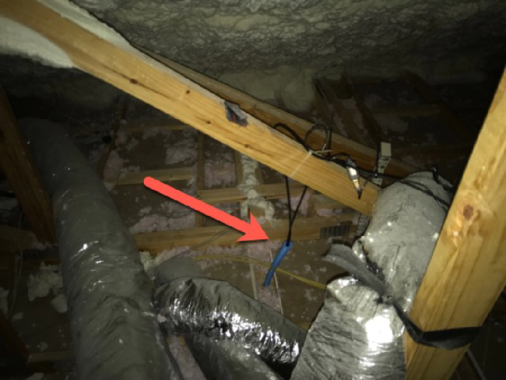 blue conduit with two cables exposed in the attic